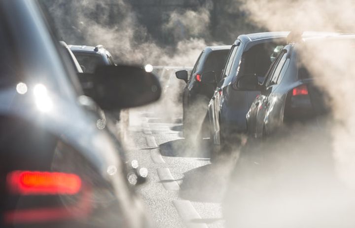 Cars in a traffic jam with pollutive smoke emitting from their exhaust fumes