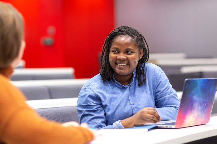 Business School student smiling in lecture hall