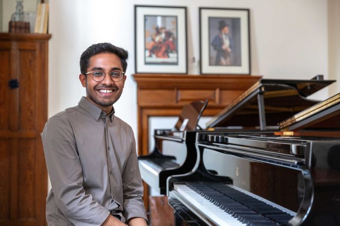 Music student sitting by piano