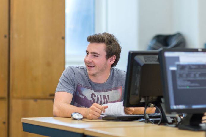 A male student sat at a computer