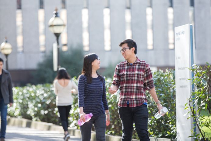 Two students walking near the Queens Lawn