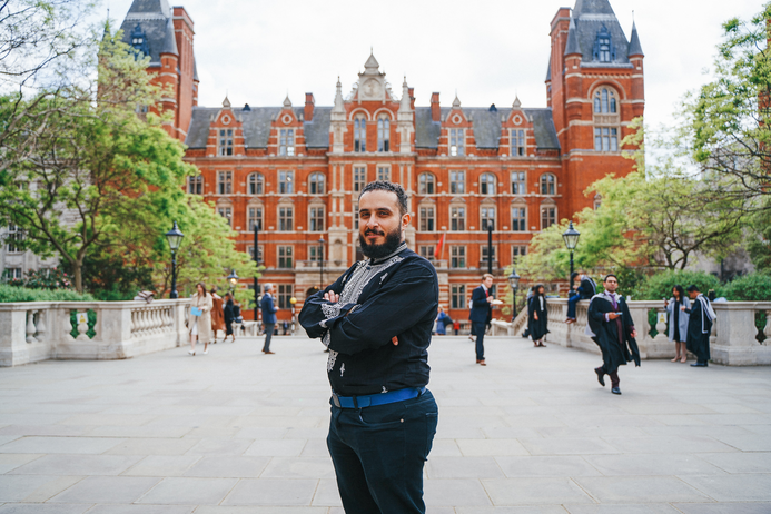 Ashraf standing looking at the camera and crossing his arms