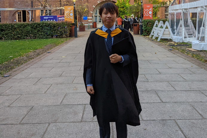 portrait of Heiloi wearing his graduation gown