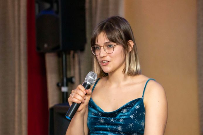 A female student holding a mic on stage