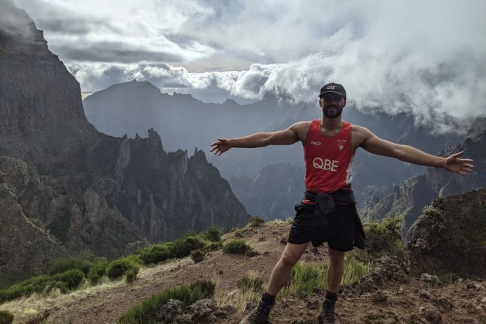 portrait of a young athletic man on a mountain top