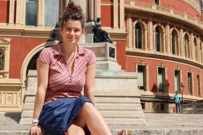 A student sitting on the stairs looking at the camera