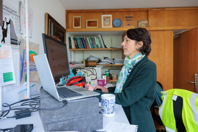 Audrey sits at a desk, looking at her computer