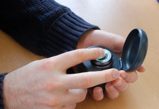 Charco Neurotech's CUE-1 Device being held in a hand