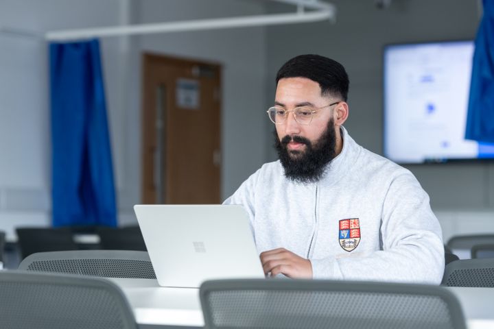 Student sits at laptop, working