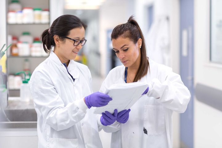 A picture of two students looking a documents in a laboratory