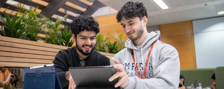 Two students working together on a laptop