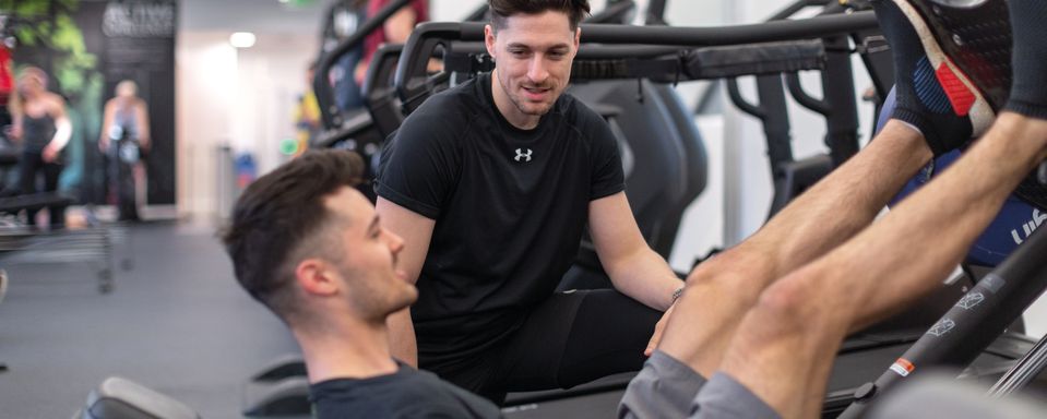 Two men working out on weight machines in Ethos gym
