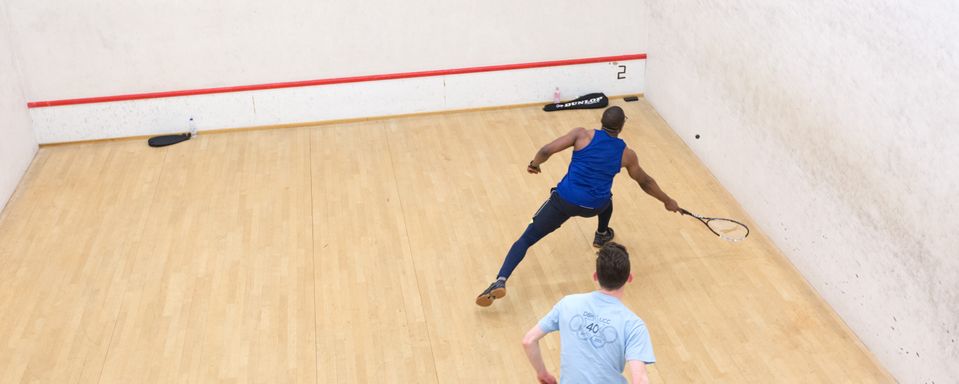Two men playing squash in a squash court