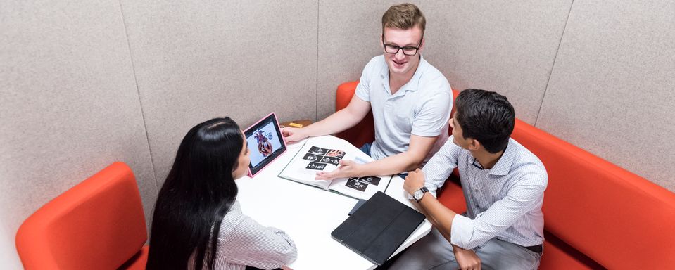 Students sit and talk at table