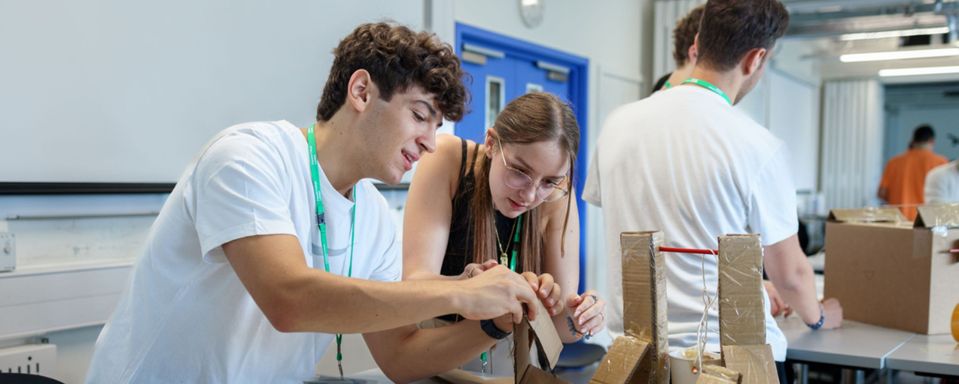 Two students stand close together in a lab setting