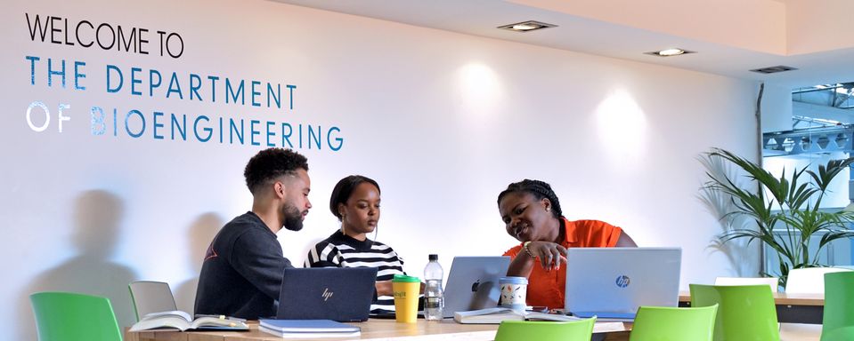 Two PhD students and a member of staff sitting at a table