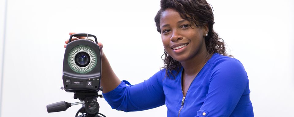 Ophelia leans against equipment in a lab