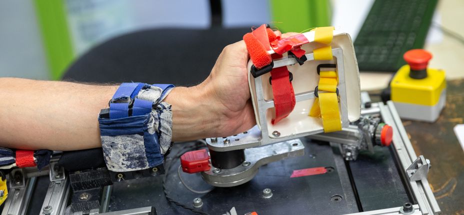 test subject using lab equipment to test hand grip