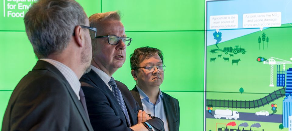 Three men in front of a screen 