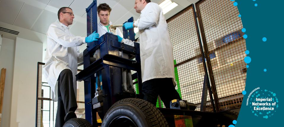 Three scientists working on a piece of machinery with wheels