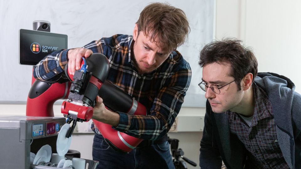 Dr Edward Johns and his robot in the lab