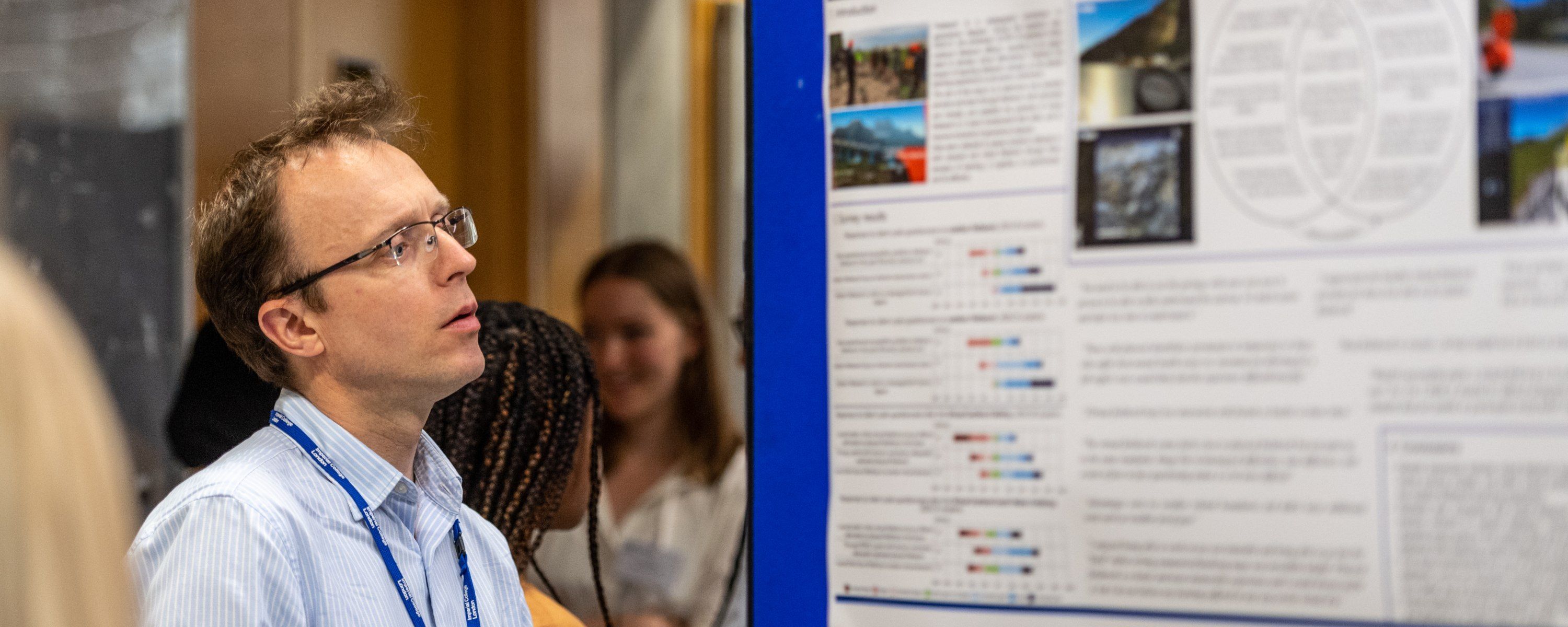 a member of staff looking at a poster