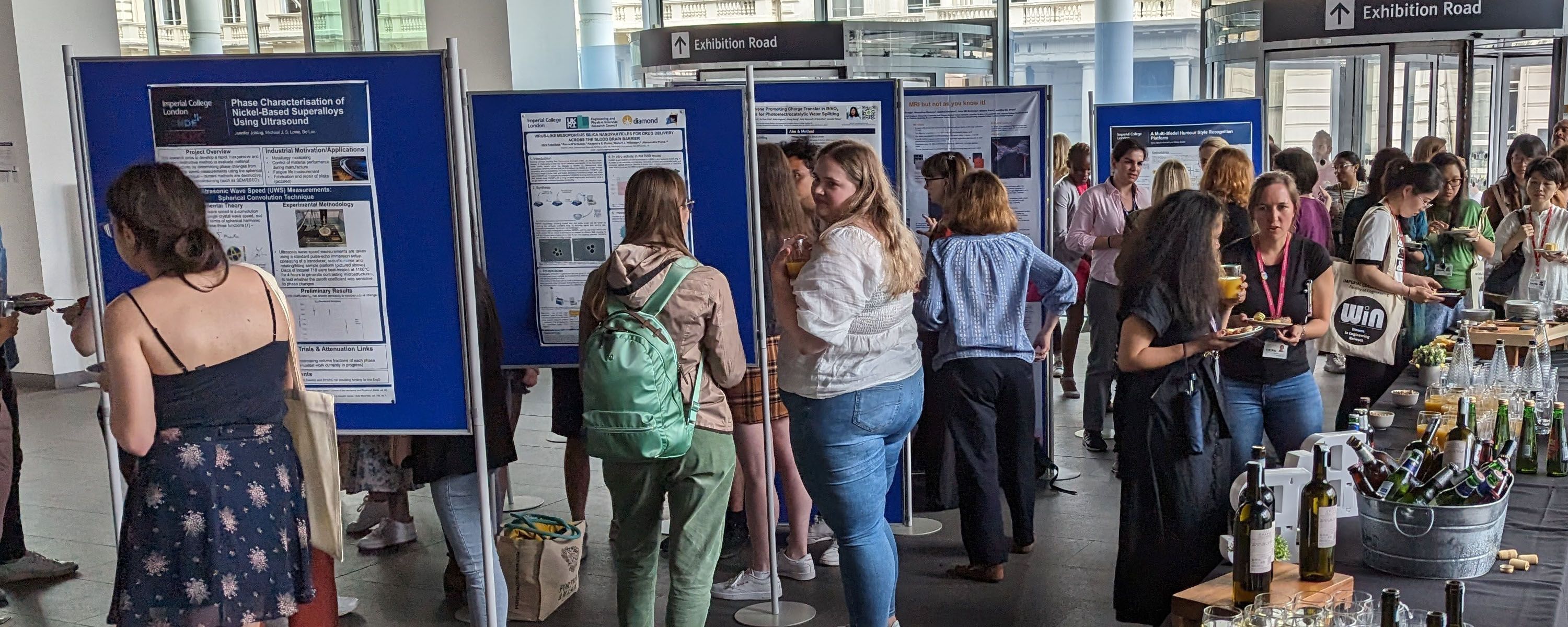 Women looking at a poster exhibition in the college main entrance