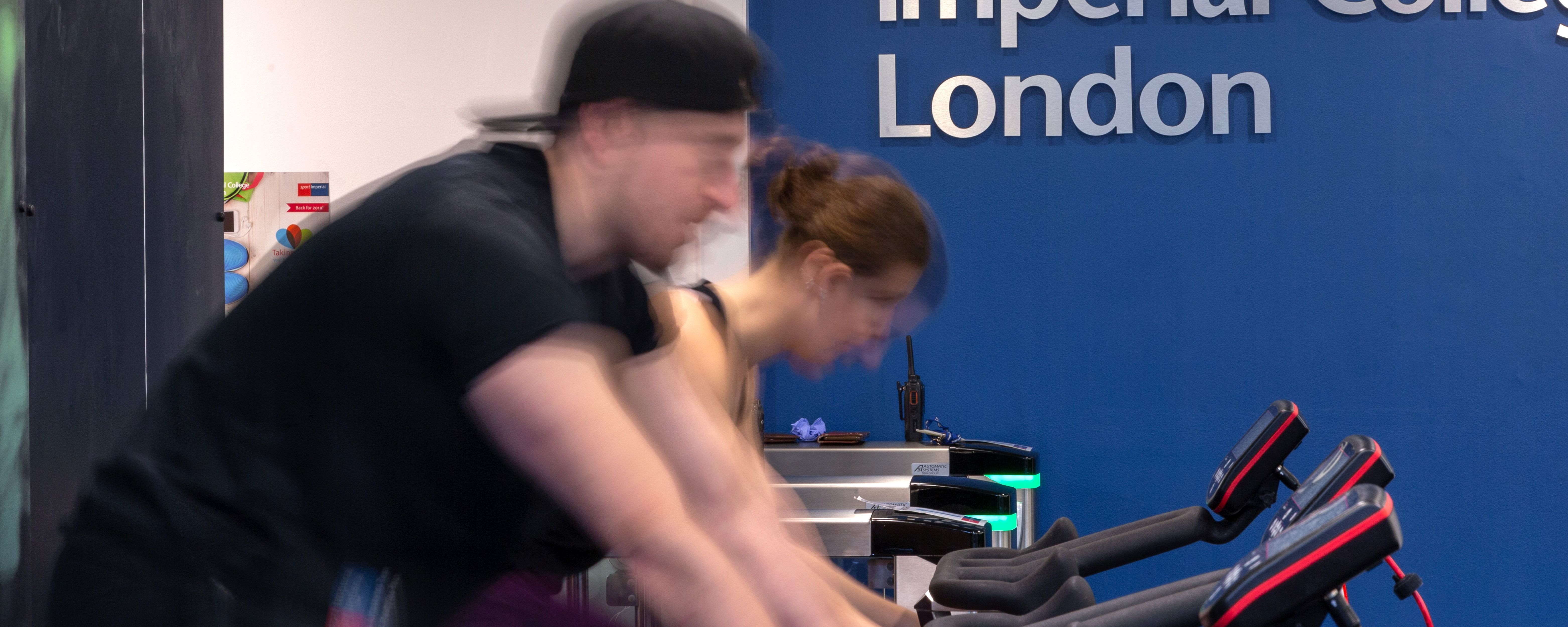 Two staff members cycling on spin machines at Ethos Gym