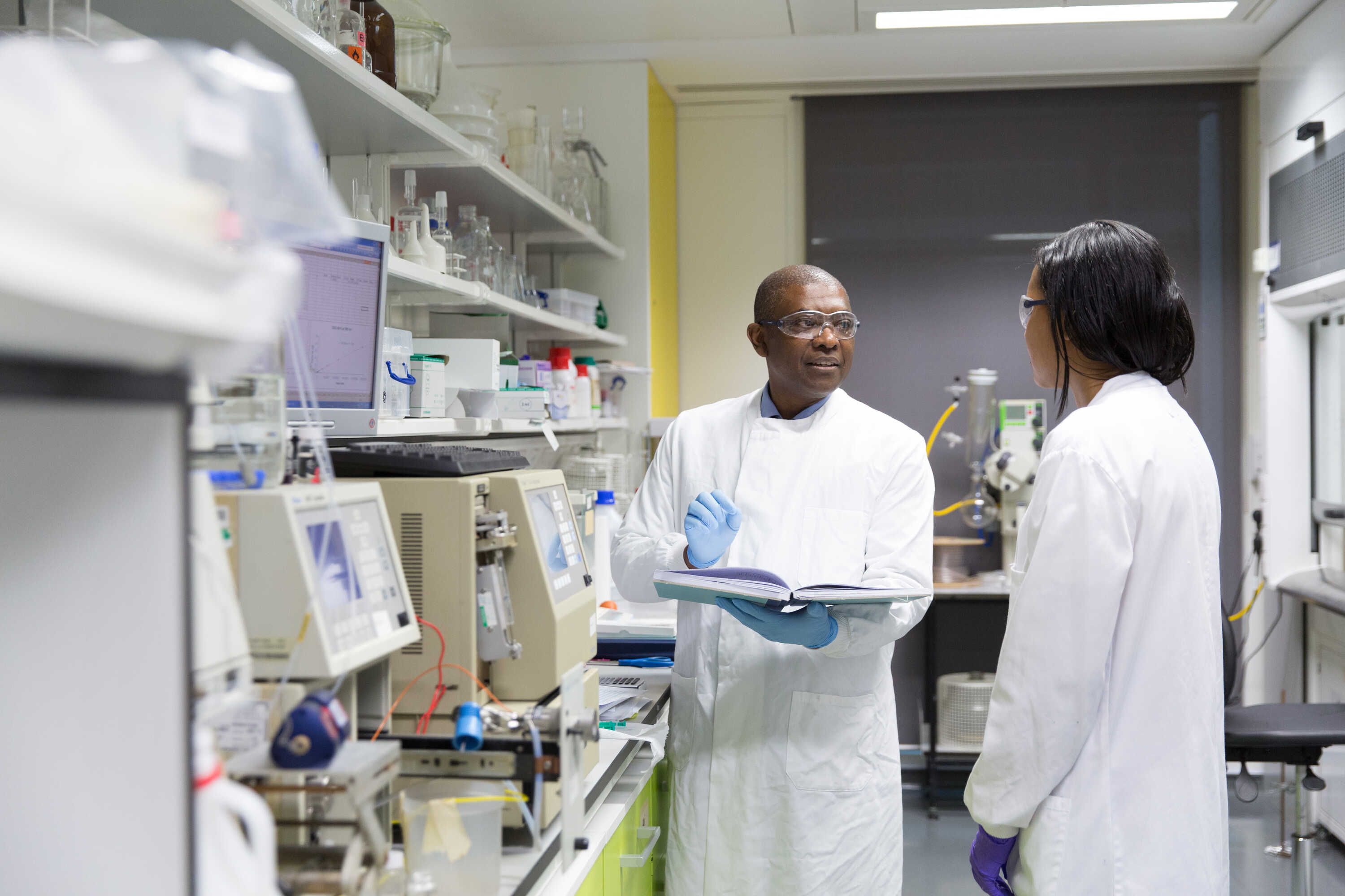 Professor Eric Aboagye talking to a postdoc in his lab