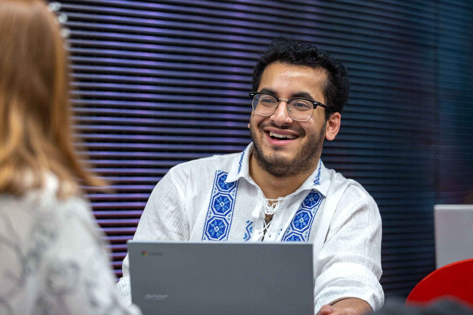 Medicine student, Mohammed, smiles while looking at a laptop