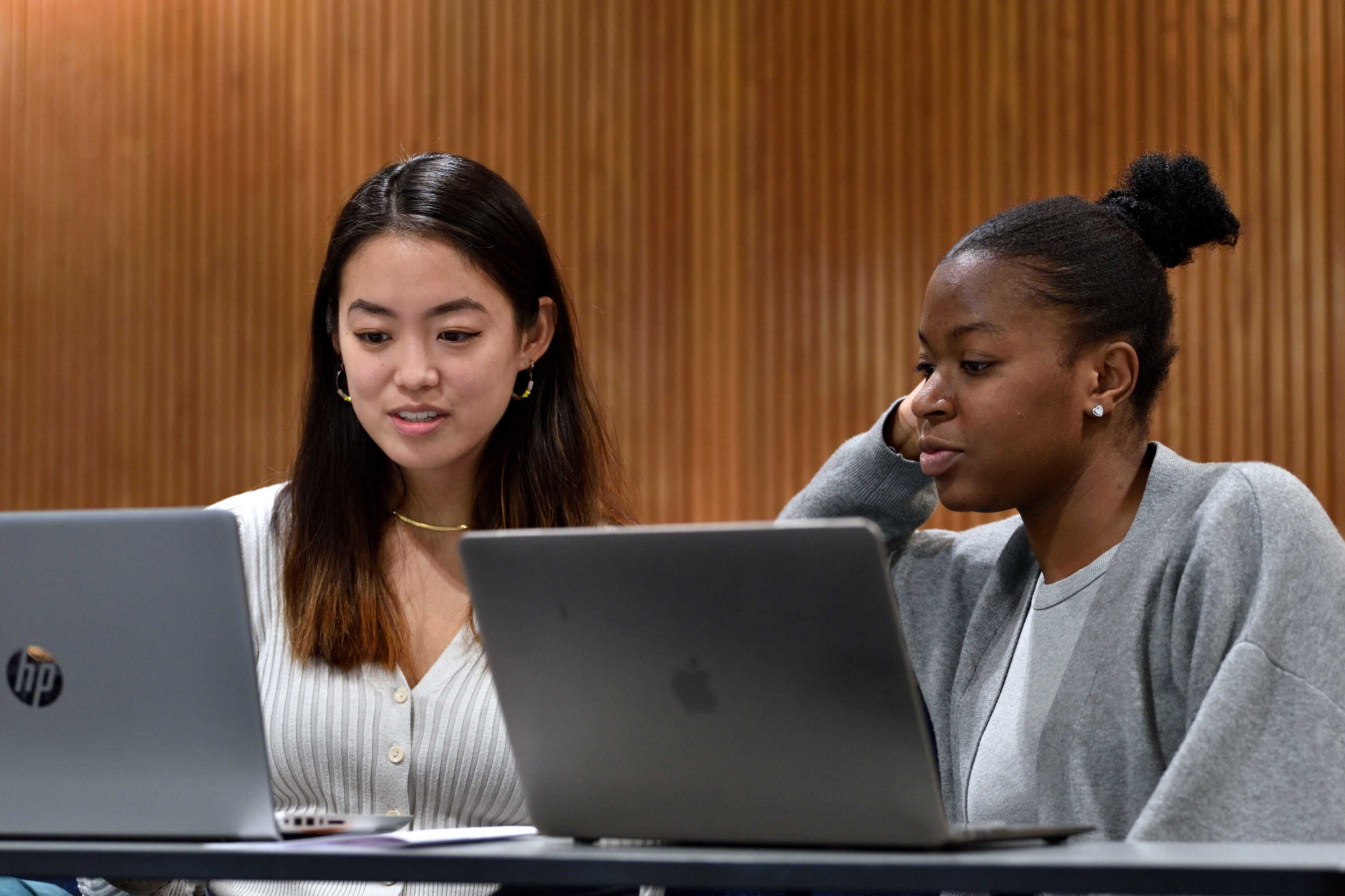 two female students looking at their laptops