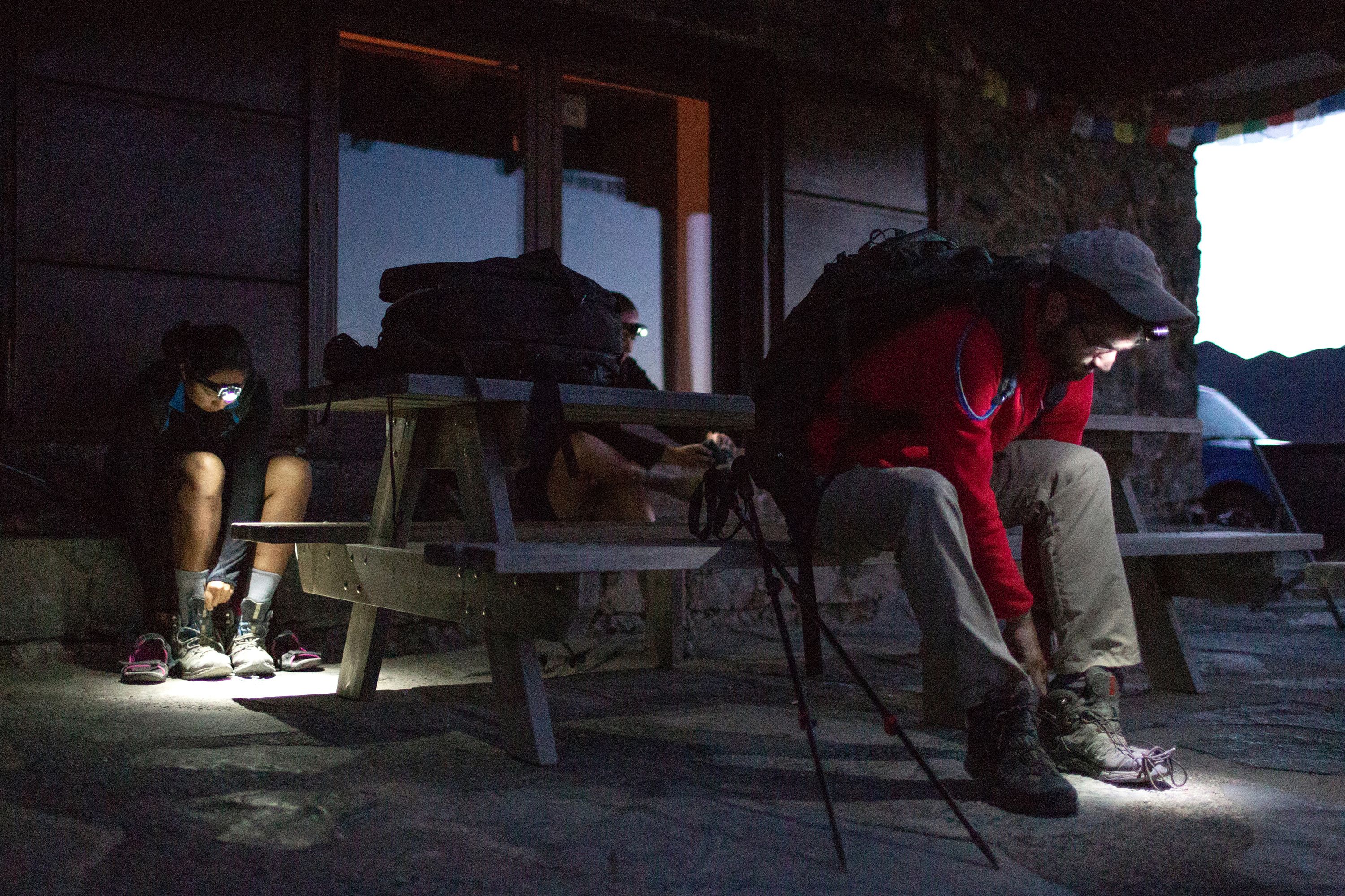 Students tying their shoelaces in the dark on an expedition in Crete