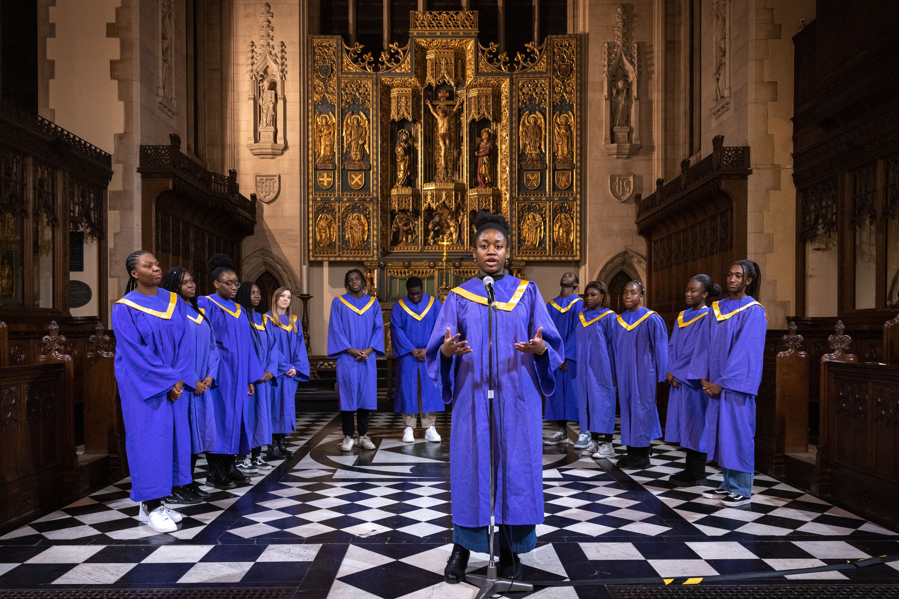 A group of singers dressed in purple performing in an ornate church