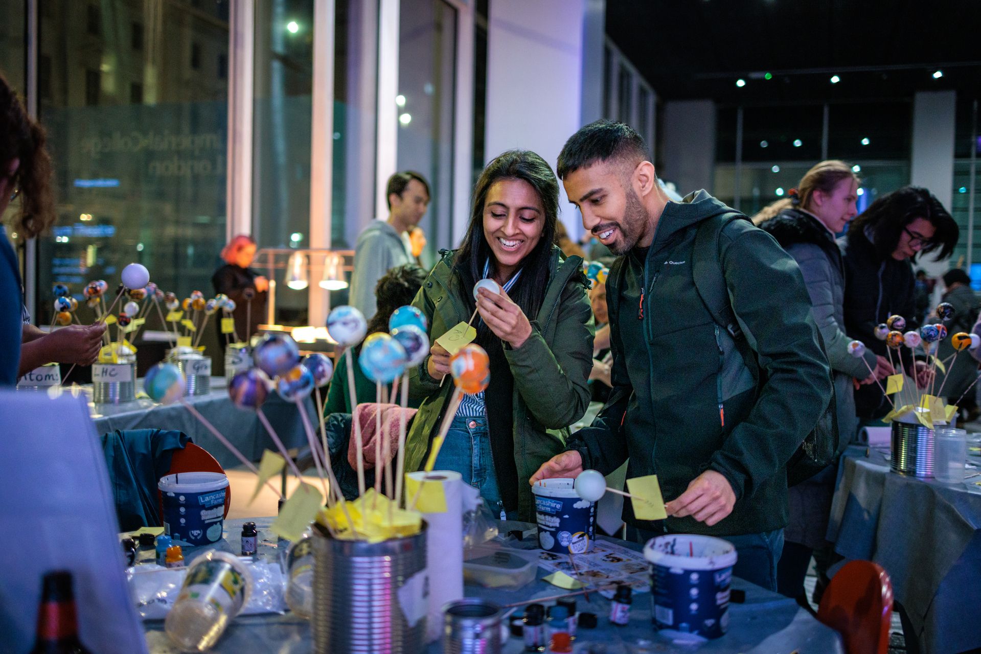 Two people making small models of planets