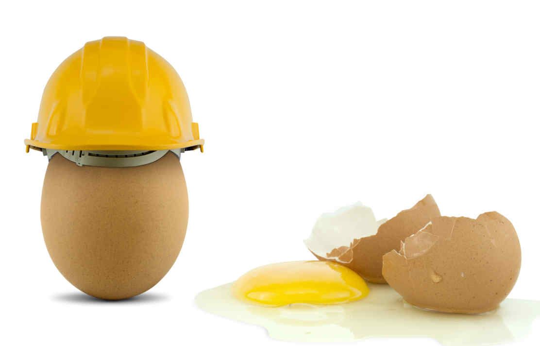 An egg with a safety helmet and a broken egg without a helmet
