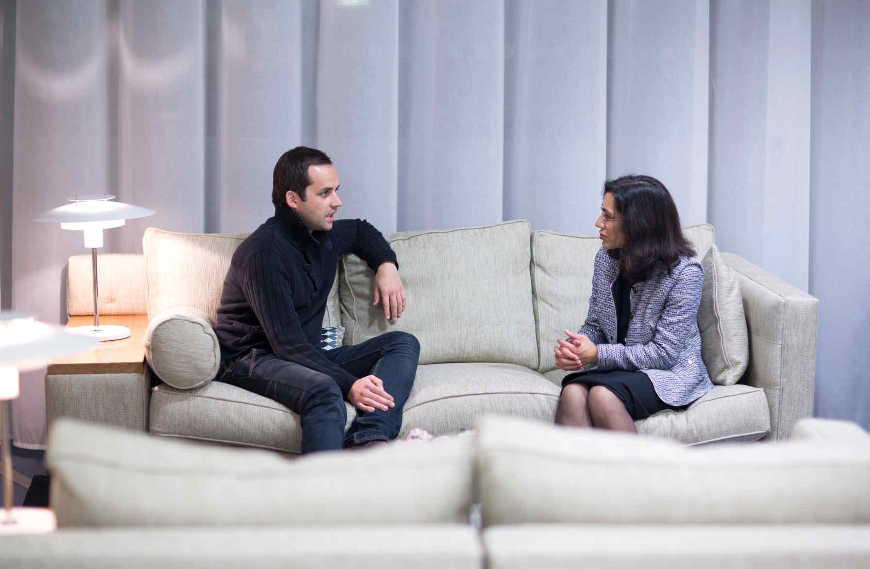 Two people sitting on a sofa in the alumni visitor centre