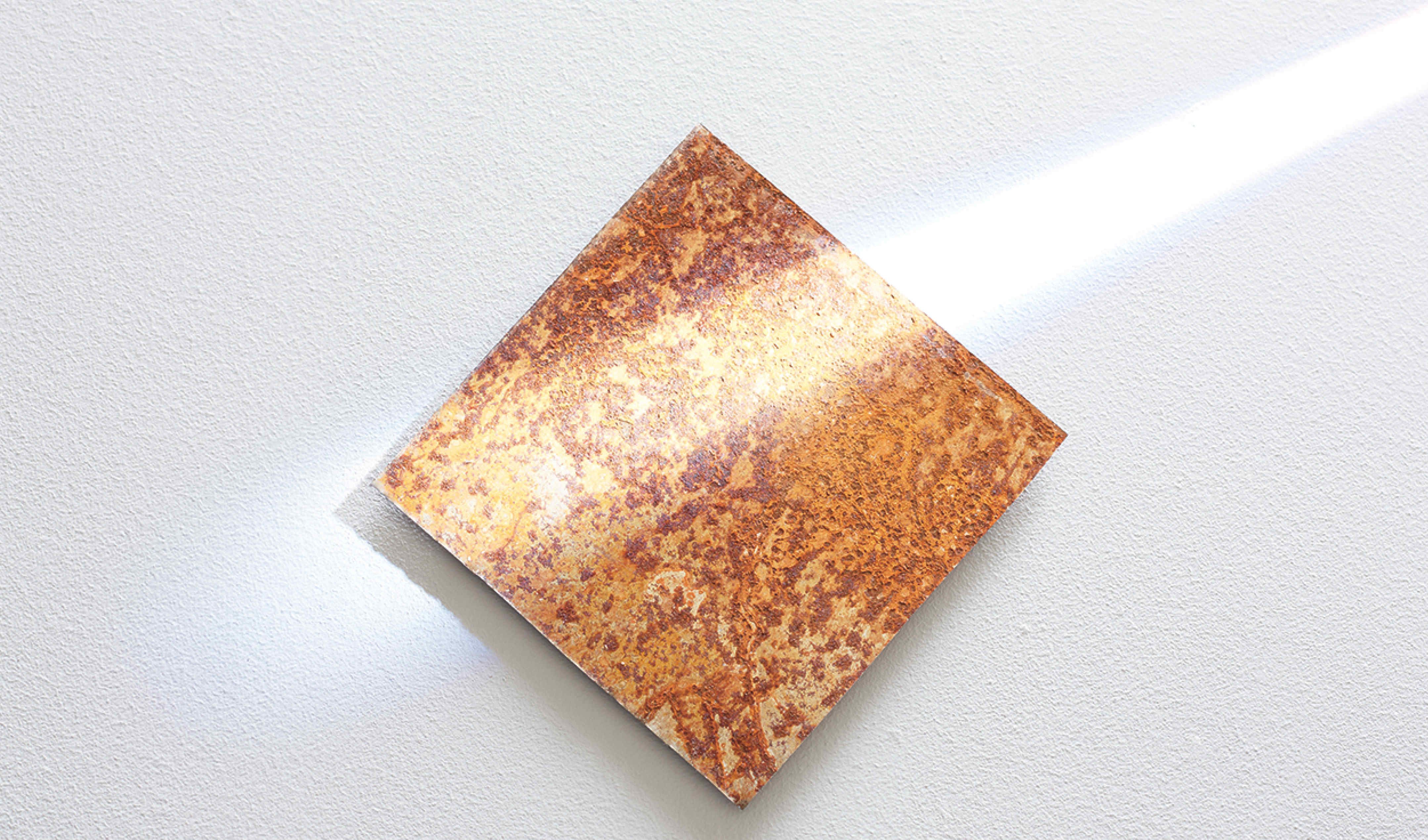 A square plate covered in rust