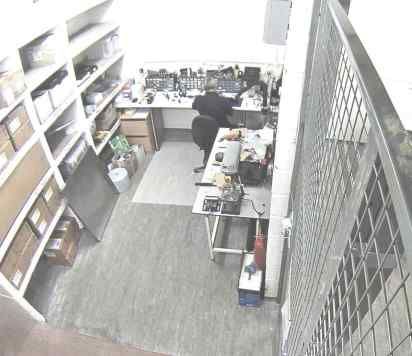 CCTV still of a member of staff working alone in a room