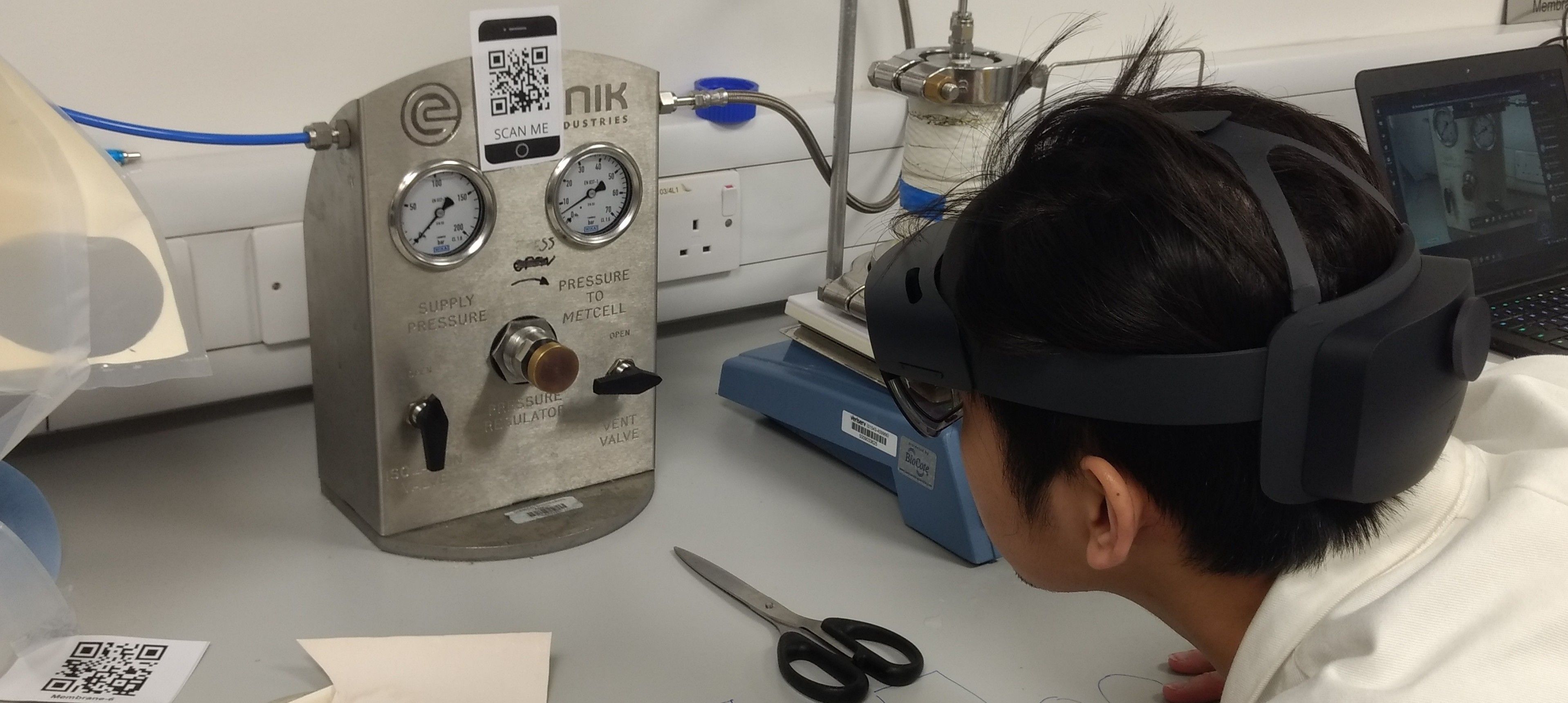 A male student looking at lab equipment