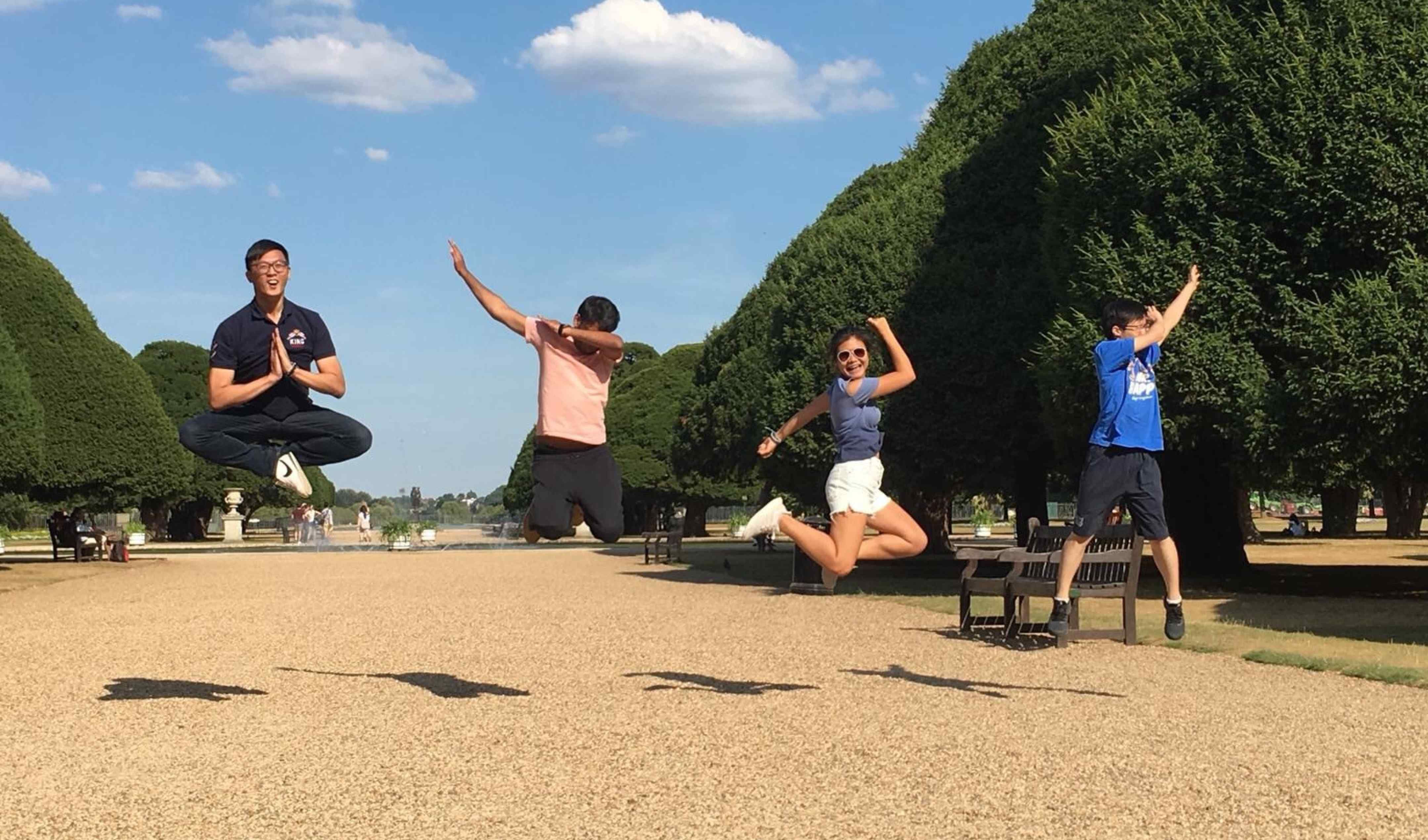Four students from the 2018 Summer School jumping in the air in Hyde Park.