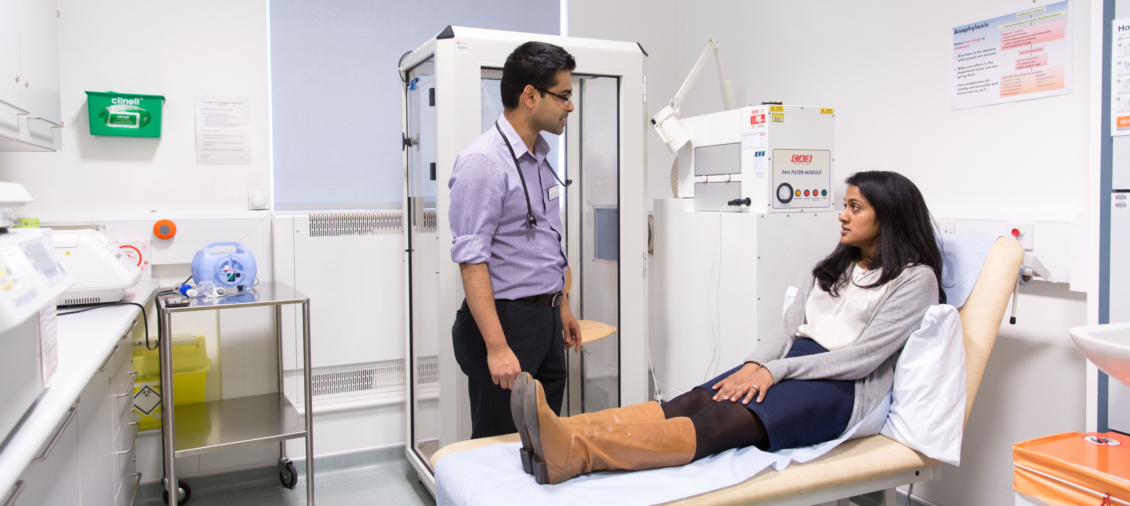 Doctor speaking to patient lying on hospital bed