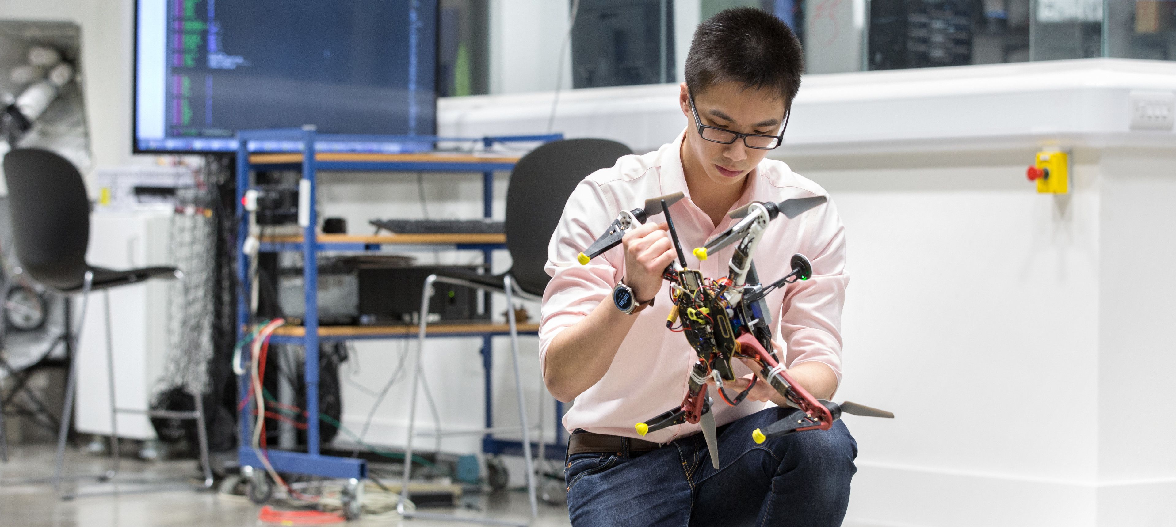 A student holding a drone in Imperial's Aerial Robotics Lab