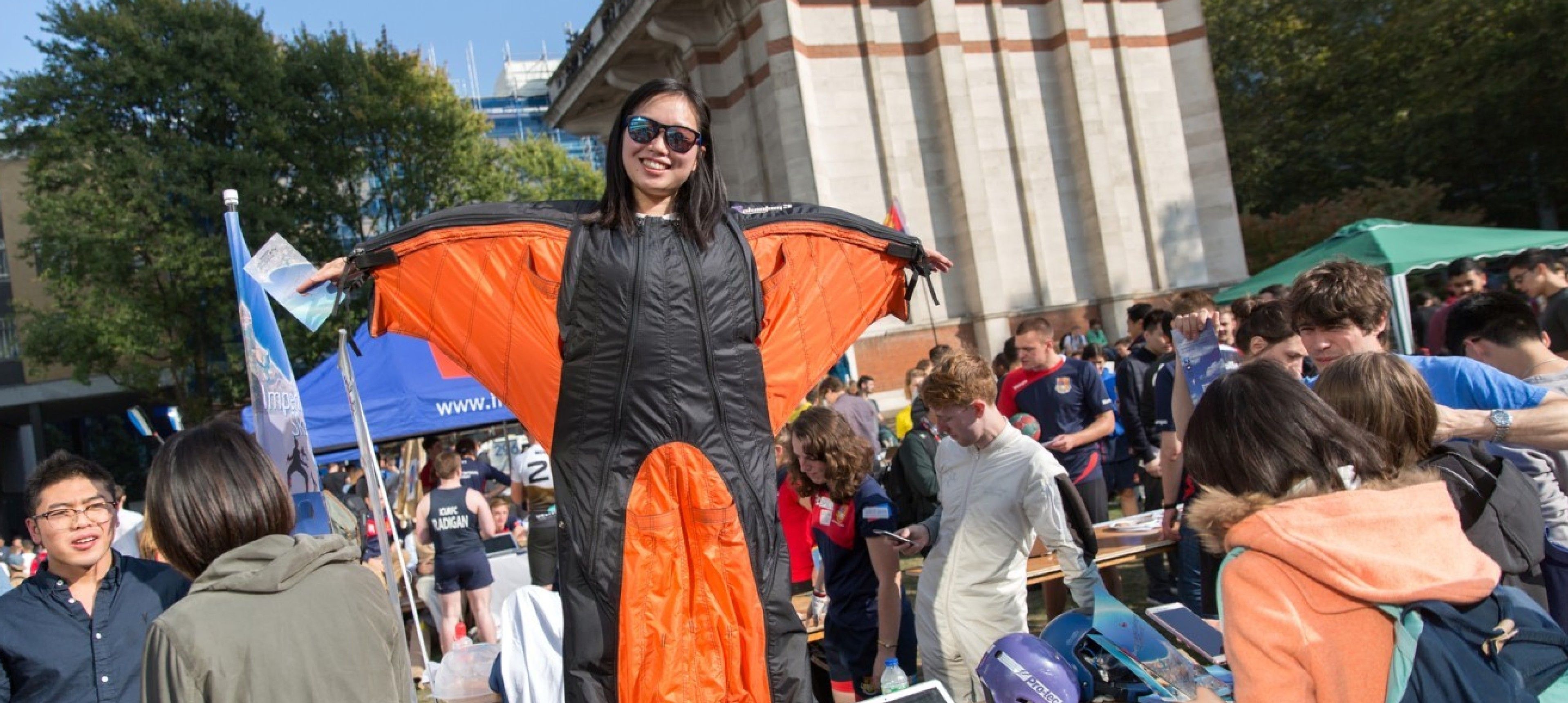 A student from Imperial's skydiving club demonstrating her winged skydiving suit at Imperial's Freshers' Fair