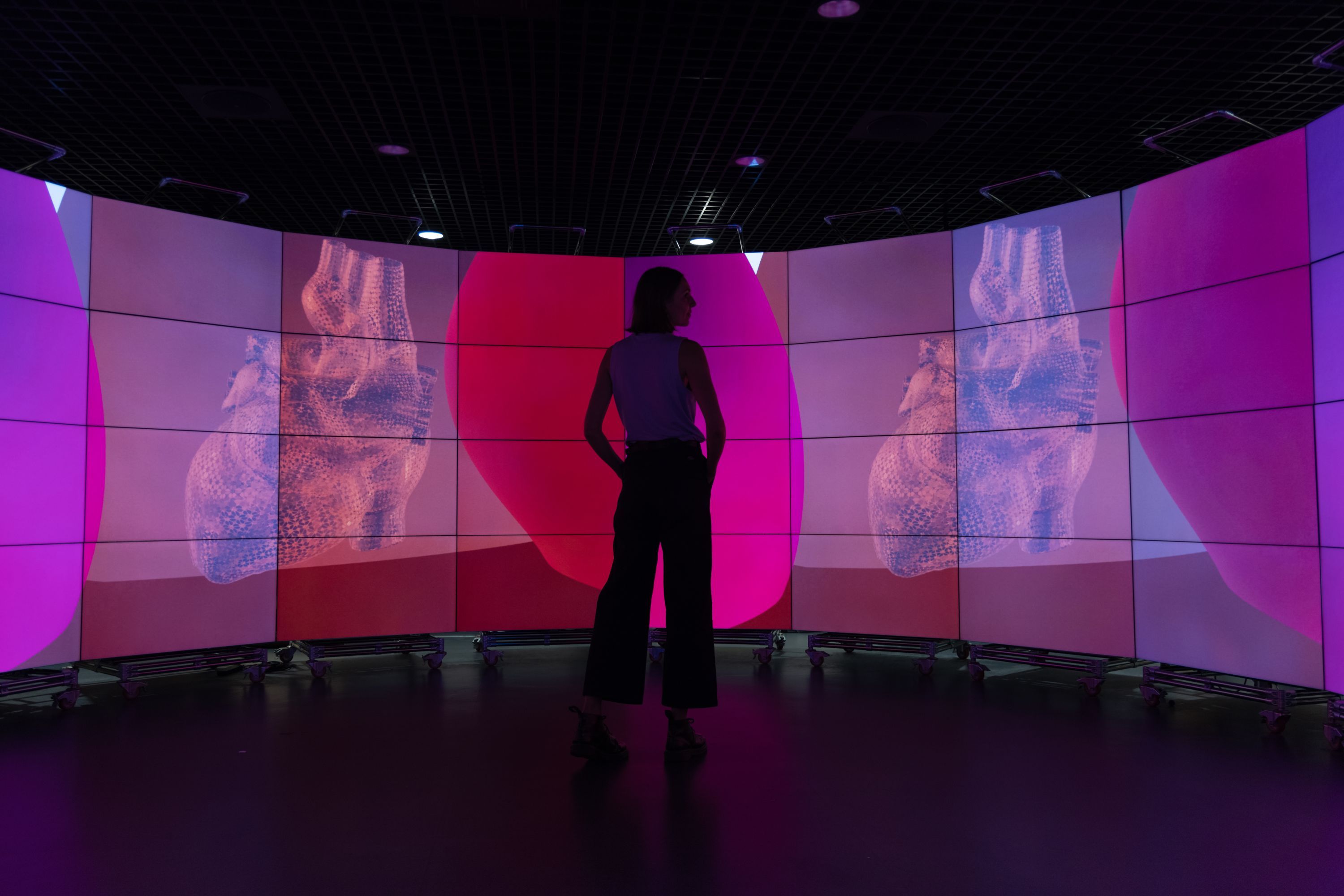 Student standing in front of data visualisation screens