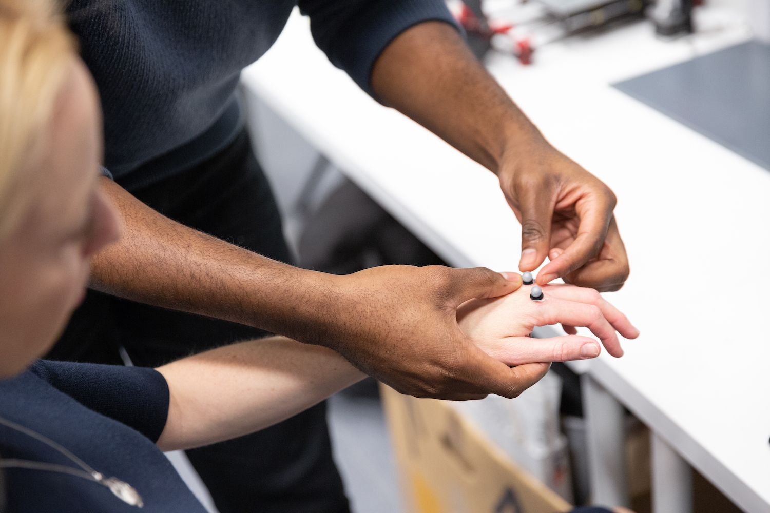 Researcher applies device to the knuckles of a subject