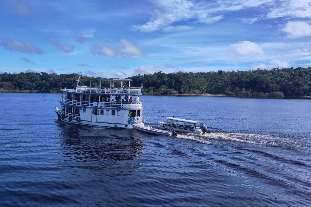 Boat full of students in the middle of a lake in the Amazon