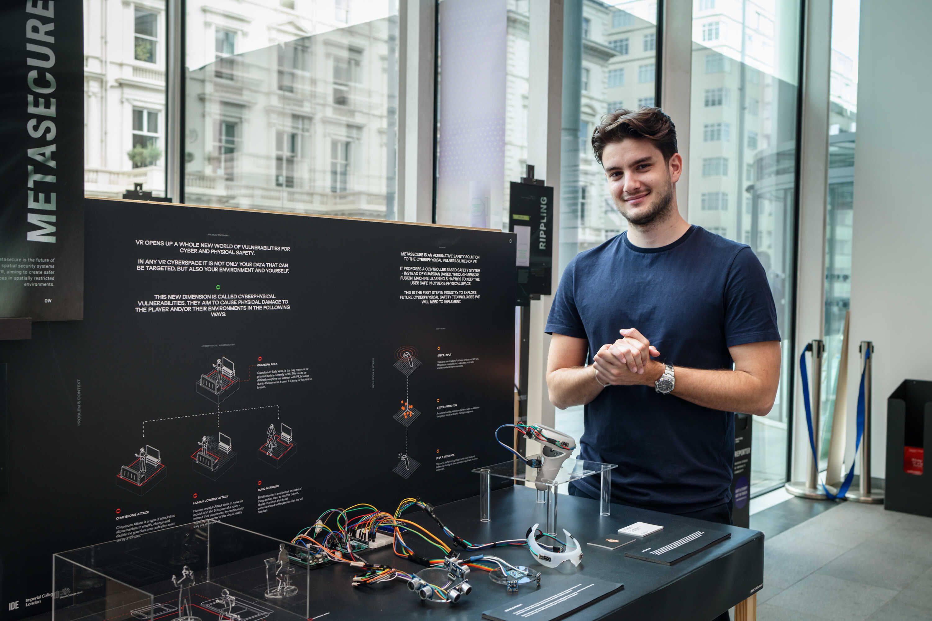 Design Engineering student standing next to project display