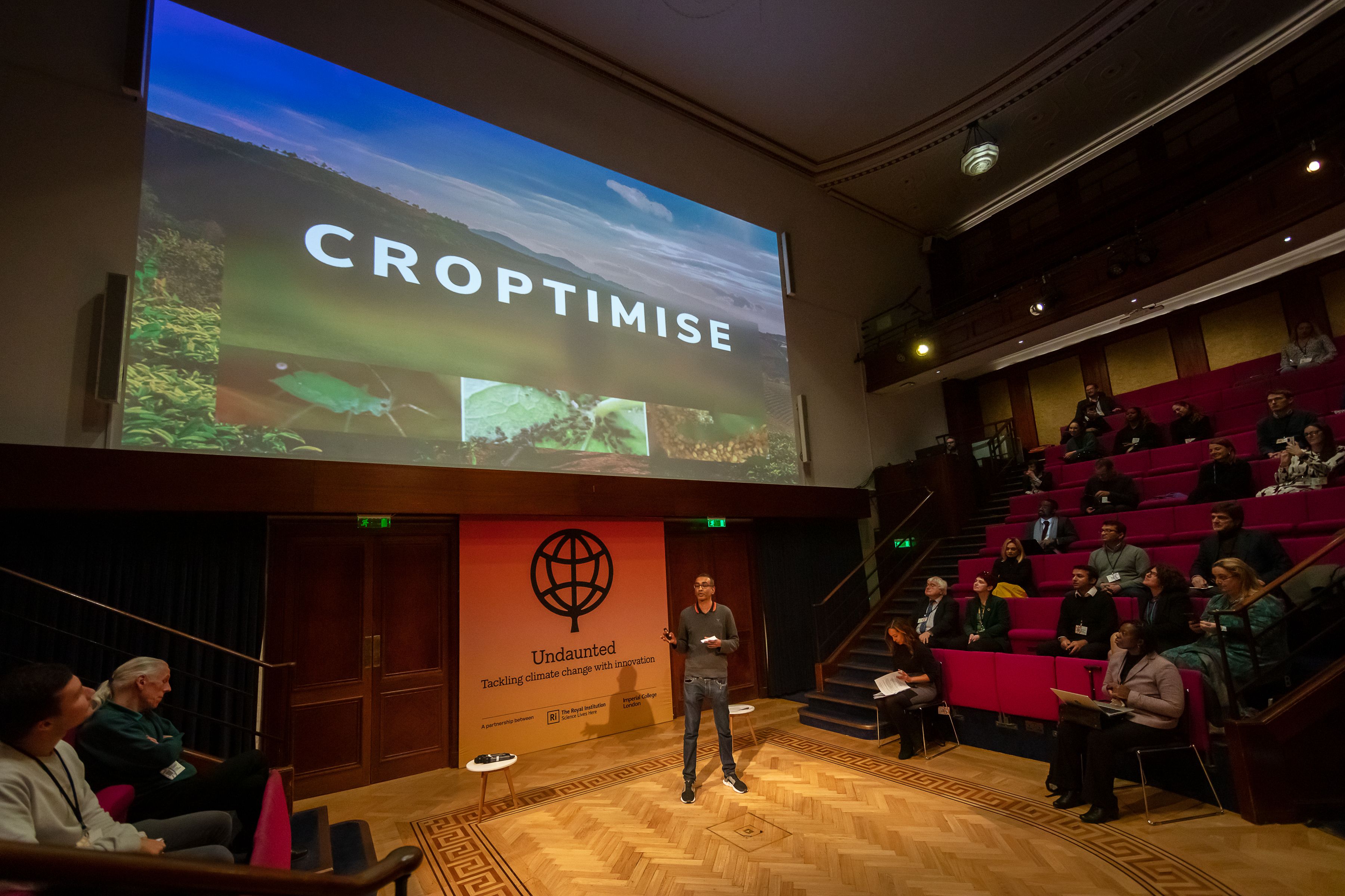 a student on a stage talking at Undaunted Demo Day 2022 at the Royal Institution