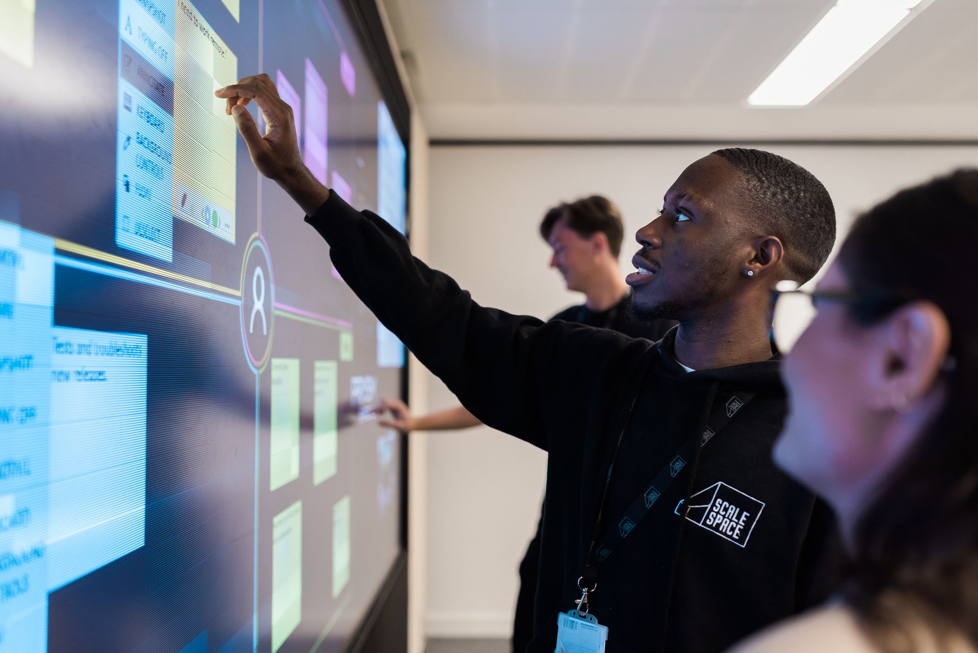 a black student in front of a digital board at the scale space