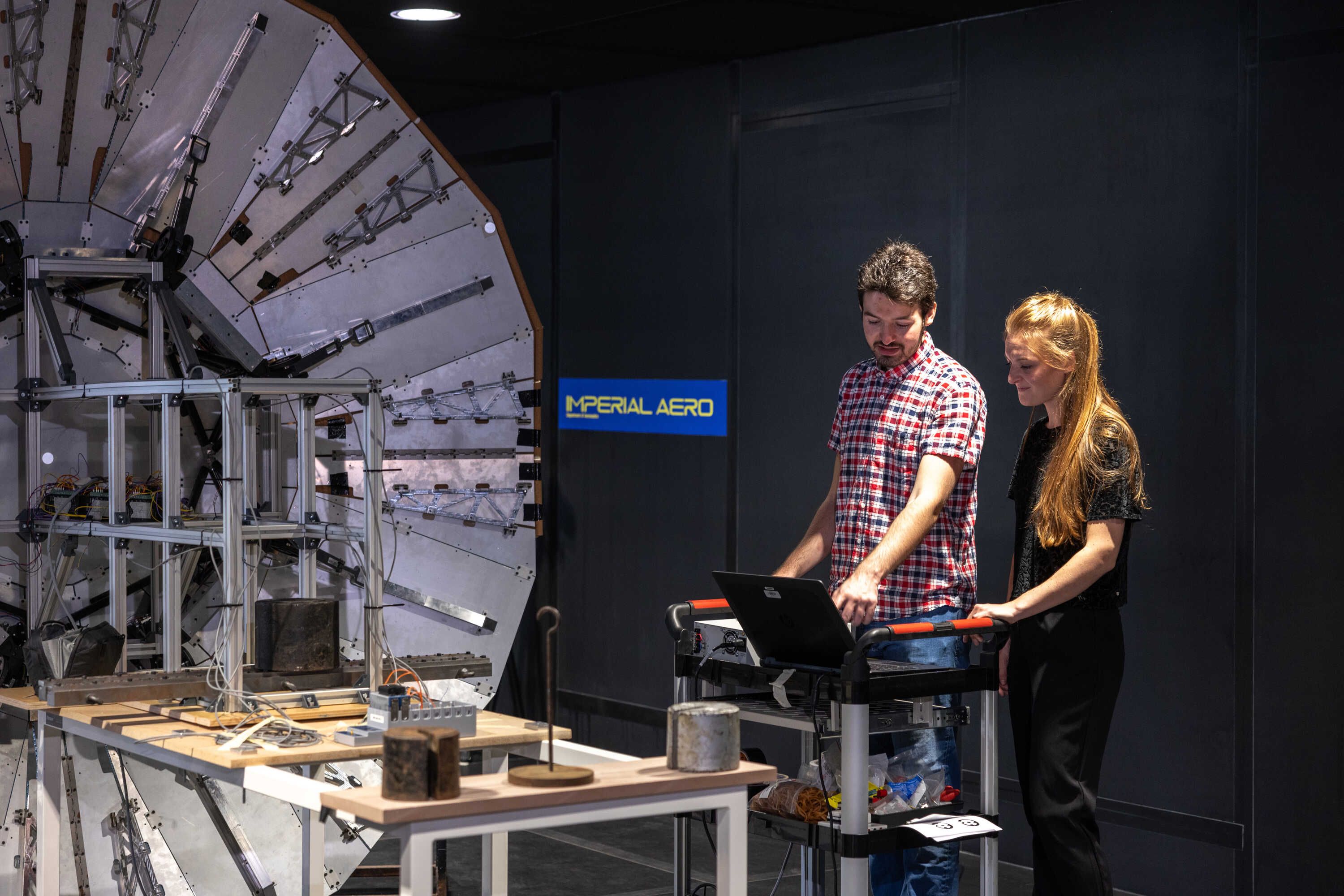 two students standing in front of a piece of spacecraft